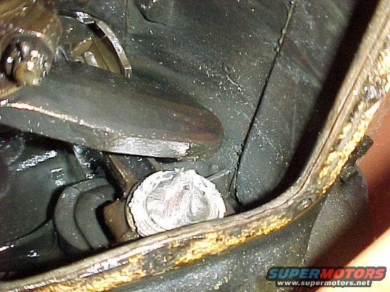 Close-up of a greasy engine component with metallic and black parts