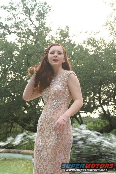 Woman in a formal dress posing by a fountain