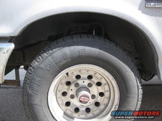 Close-up of a truck's front wheel and fender well. Tire has 'BIG O A/T' visible