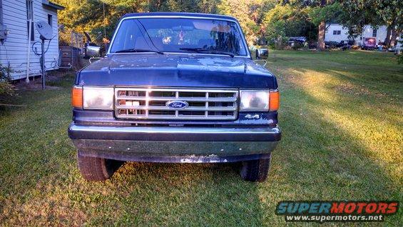 Front view of a blue 1988 Ford Bronco with a chrome grille and 4x4 badging