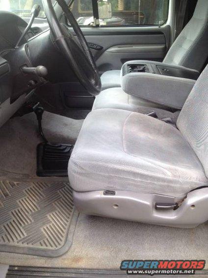 Interior shot of a truck's front seats, steering wheel, and center console