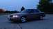 2005 Ford Crown Victoria - A gray Ford Crown Victoria is parked in a lot as the sky darkens.