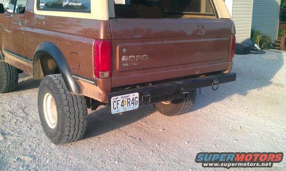 Brown Ford Bronco rear view, showing aftermarket bumper, large tires, and a Missouri license plate