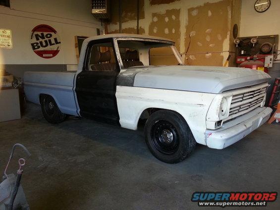 1967 Ford F-100 in garage, primer and blue paint, front 3/4 view