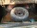 1988 Ford Bronco - Spare tire located in the trunk of a vehicle, showing signs of wear and tear.