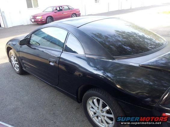 Black coupe, possibly a Mitsubishi Eclipse, parked next to a red sedan