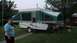 2006 Yugo Vega - A woman stands next to a Viking pop-up camper trailer parked on a grassy lawn.