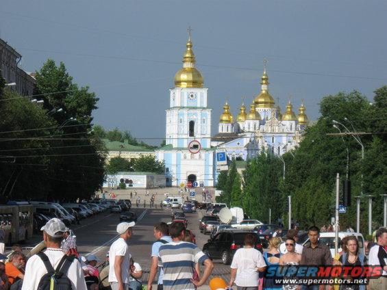 Street scene with a large church with golden domes and traffic
