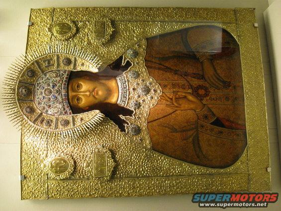 Ornate gold-covered religious icon depicting a figure's face and hands