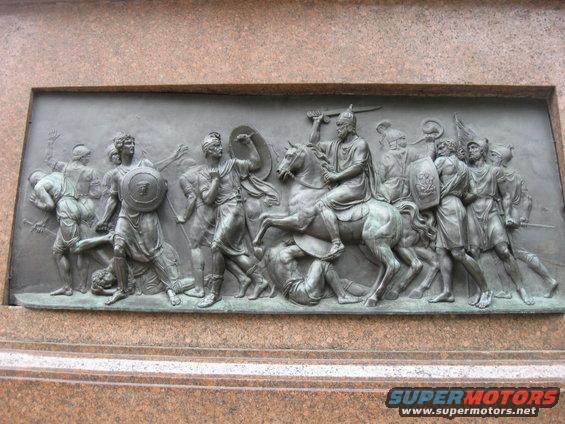 Bronze relief sculpture depicting a battle with a horse-mounted warrior