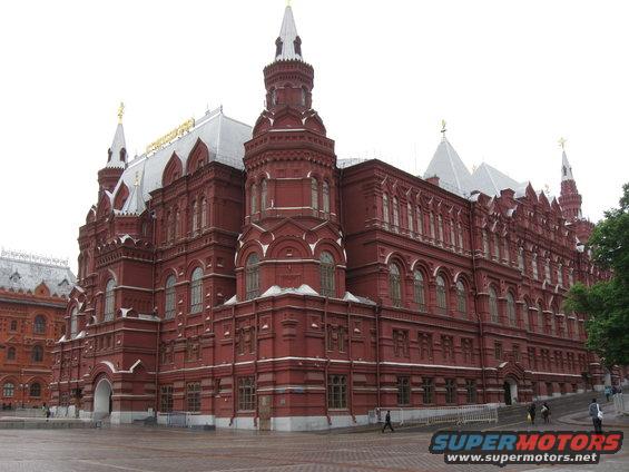 Large red brick building with multiple towers and arched windows