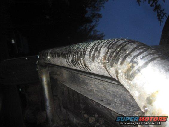 close-up of a dirty, wet exhaust pipe with black stripes