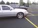 2003 Ford Crown Victoria - A silver sedan is parked in a lot next to a dark sedan.