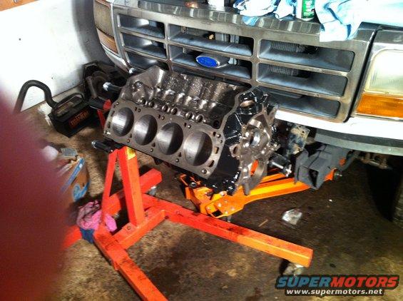 1992 Ford Bronco grille with a V8 engine block on an orange stand in front
