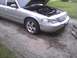 2003 Ford Crown Victoria - The front of a silver 2003 Ford Crown Victoria is shown with the hood open, revealing the engine compartment.
