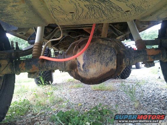 Rear axle assembly with orange hose and leaf springs, viewed from underneath
