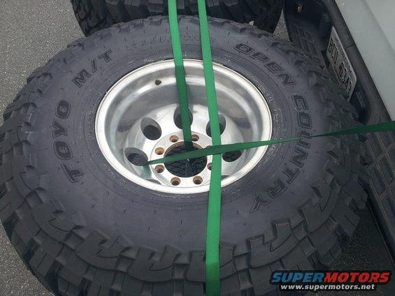 Spare Toyo Open Country M/T tires strapped to a white vehicle