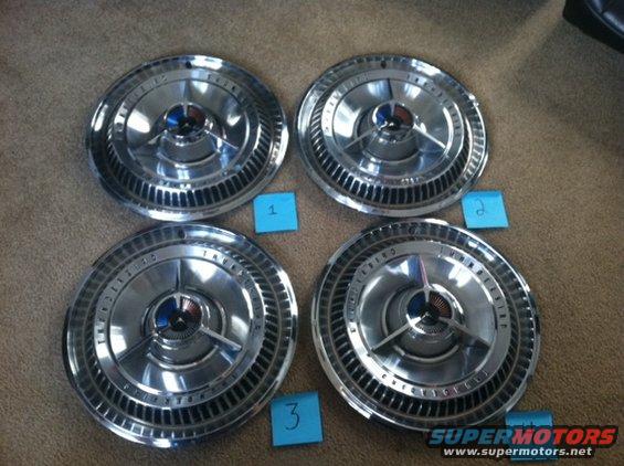 Four chrome hubcaps with blue and red accents, labeled 1, 2, and 3