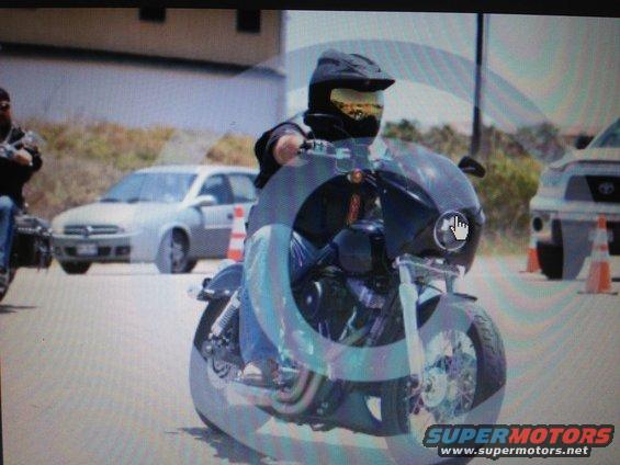 Front view of a motorcycle with a rider wearing a helmet and goggles