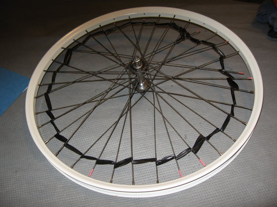 bicycle wheel with black tape wrapped around spokes