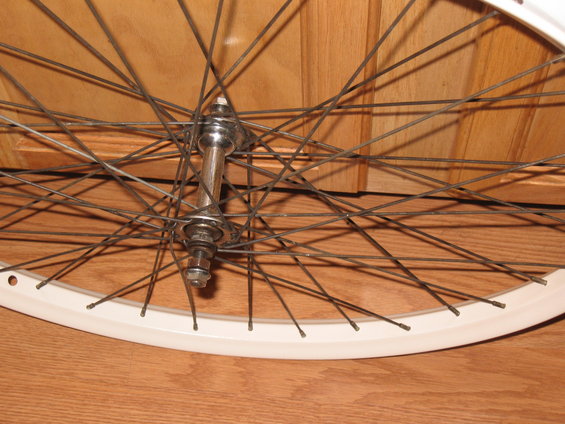 Close-up of a bicycle wheel with a silver hub and white rim