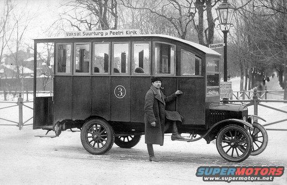 Man in coat steps into a bus with windows and a sign above. A number 3 is on the side