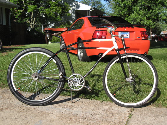 Custom bicycle with a red Ford Mustang in the background