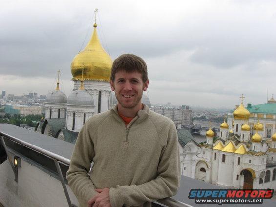 Man posing with golden-domed buildings in background
