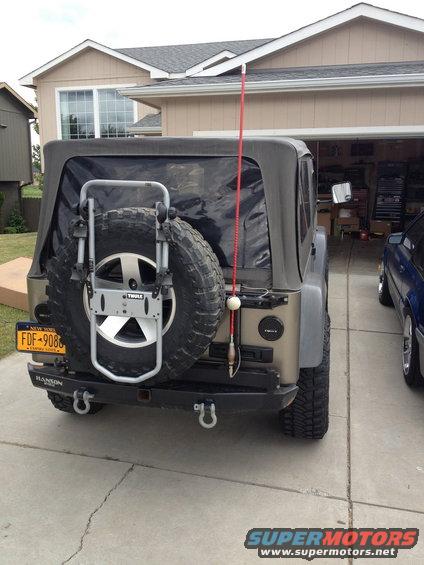 2005 Jeep Wrangler rear view with spare tire mounted on carrier, Thule rack, and Hanson bumper