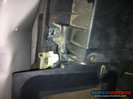 Close-up of a plastic car interior component with a white clip mechanism