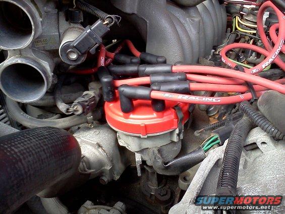 Engine distributor cap with red wires labeled 'RACING'