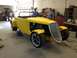 1975 Ford Ranchero - A bright yellow custom roadster sits in a workshop, its engine exposed and front end a prominent chrome grille.