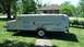 2006 Yugo Vega - A white Viking pop-up camper trailer is parked on a grassy lawn in front of a house.