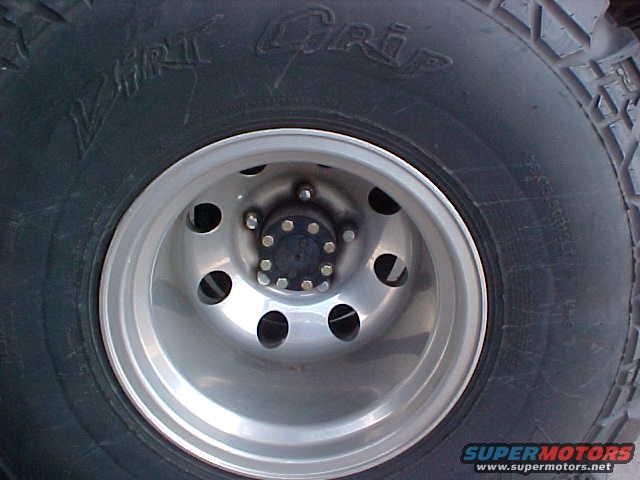 Close-up of a tire with 'Dirt Grip' text and a silver wheel with 5 lug nuts