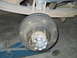 1992 Ford Bronco - Close-up view of a rear drum brake assembly, likely from a truck or SUV, supported by a jack.