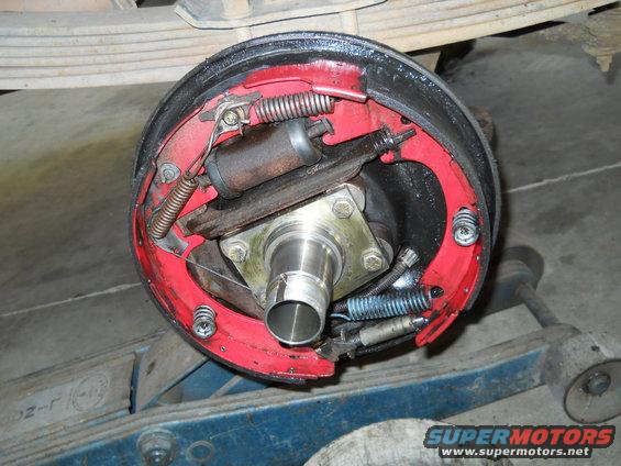 Drum brake assembly with red shoes, showing springs, cylinder, and hub