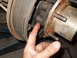 1992 Ford Bronco - A finger points to a part of the brake drum and hub assembly on a vehicle.