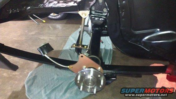 Rear suspension assembly with leaf spring and brake rotor