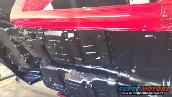 Underside of a car with red body panels and black undercarriage