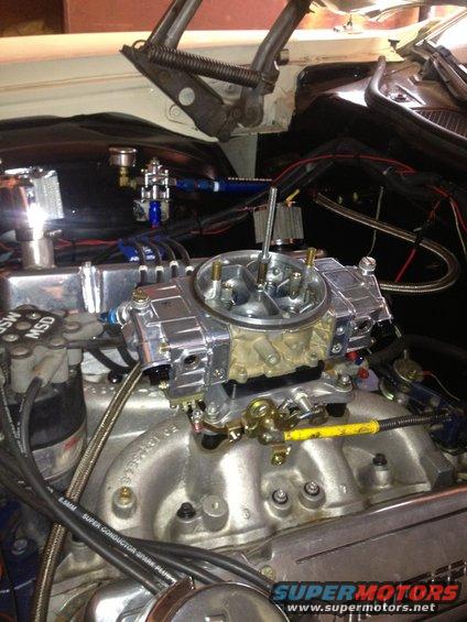 Engine bay showing a chrome carburetor, MSD ignition box, and fuel lines