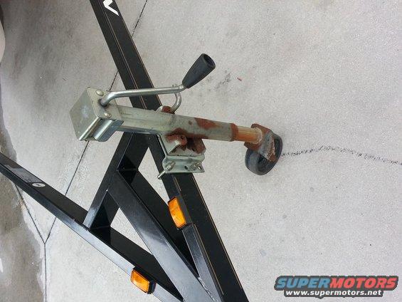 Boat trailer tongue with rusty coupler, black handle, and small wheel