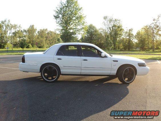 White 2000 Mercury Grand Marquis sedan, side view, black rims