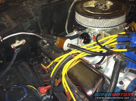 Engine bay with V8 engine, air filter, carburetor, and yellow spark plug wires