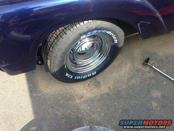 close-up of a shiny chrome wheel with BFGoodrich Radial T/A tires on a dark blue classic car