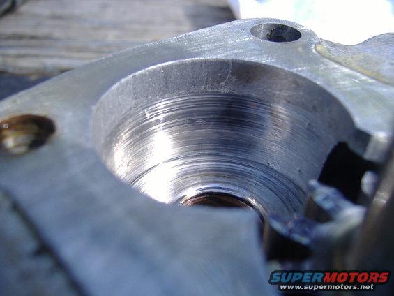 Close-up of a machined metal part showing internal threads and some wear