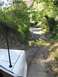1992 Ford Explorer - A white SUV navigates a dirt road with a water puddle, surrounded by lush green trees.