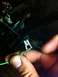 1995 Ford Mustang - Close-up of a hand holding a green wire with a metal connector, part of a vehicle's electrical system.