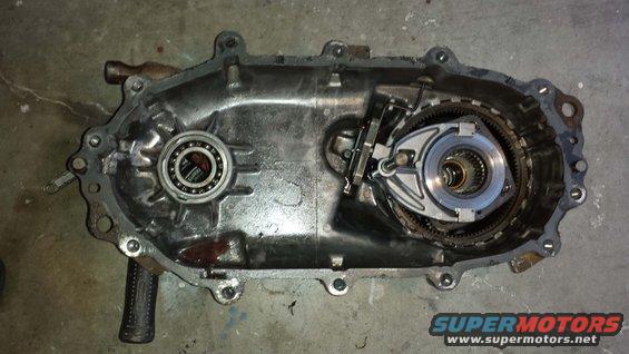 Open metal transfer case with bearing and gears visible