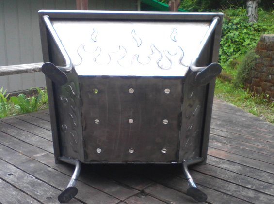 Metal fire pit with flame cutouts on a wooden deck