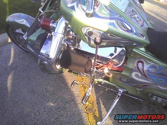 Chopper motorcycle with custom green paint, airbrushed designs, and a visible turbocharger and air filter